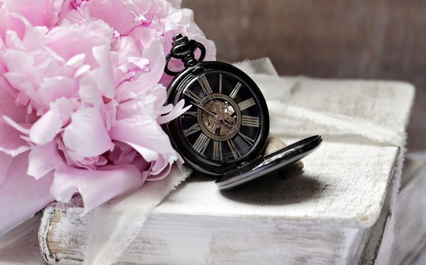 Zegar i kwiat leża na starej książce