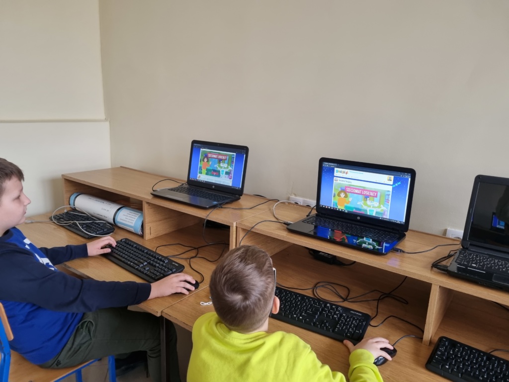 Zdjęcie nr 2 przedstawia uczniów w pracowni komputerowej, którzy oglądają stronę internetową sieciaki.pl