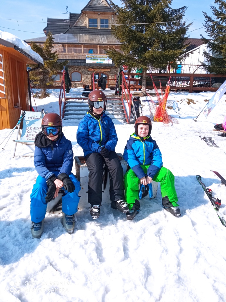 Zawody na stoku w jeździe slalomowej na nartach zjazdowych – na podium zwycięscy zawodów-chłopcy.