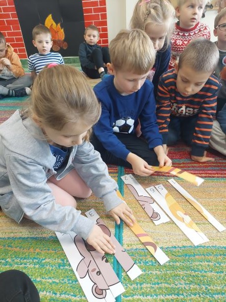 uczniowie na dywanie układają puzzle; sala lekcyjna; 