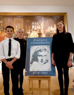 Milena Sobiesiak, Piotr Staropiętka - laureaci konkursu stoją w towarzystwie opiekunki artystycznej przy portrecie Grażyny Chrostowskiej