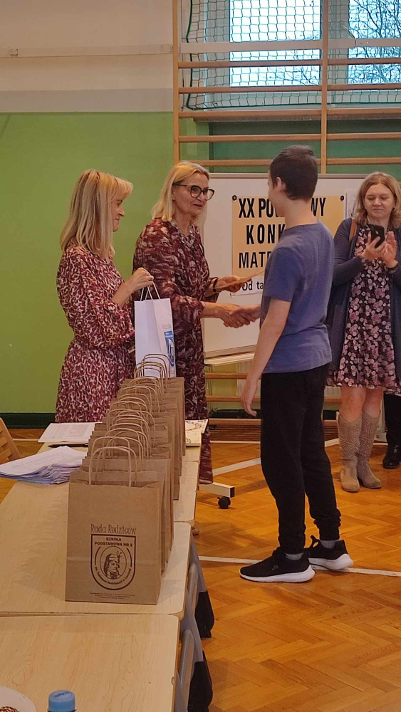 zwycięzca konkursu Michał Jakubowski odbiera dyplom od pani dyrektor Hanny Lipińskiej -Stopy