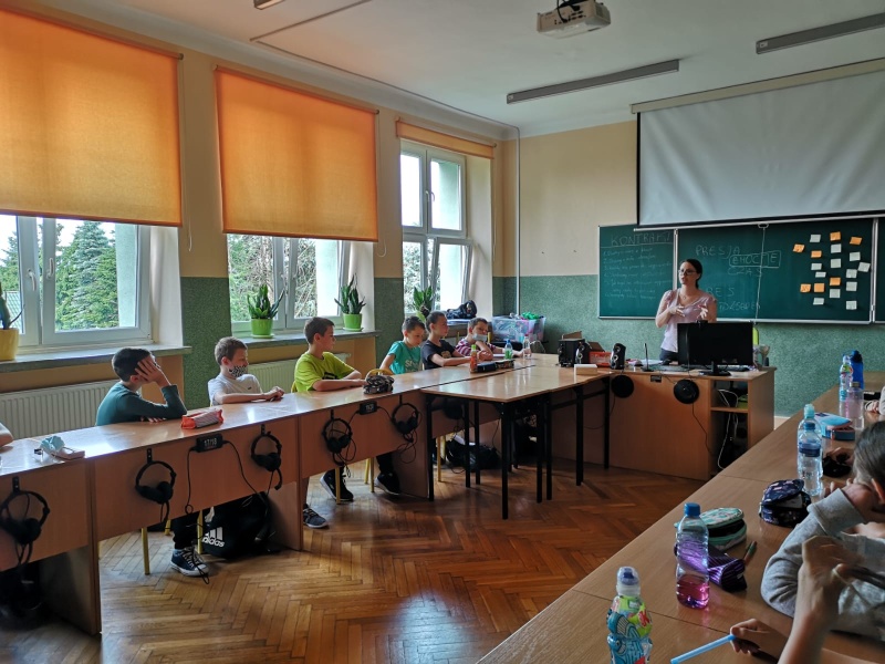 Uczniowie w trakcie debaty. Siedzą wokół okrągłego stołu