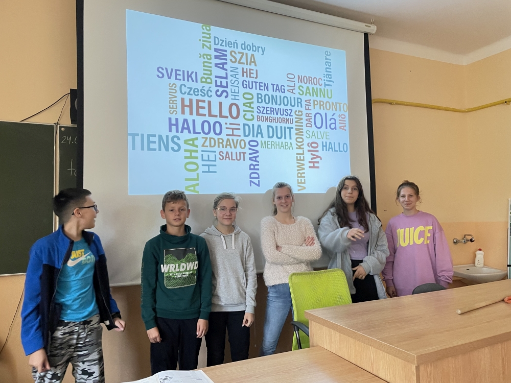 Grupa uczniów stoi przy tablicy