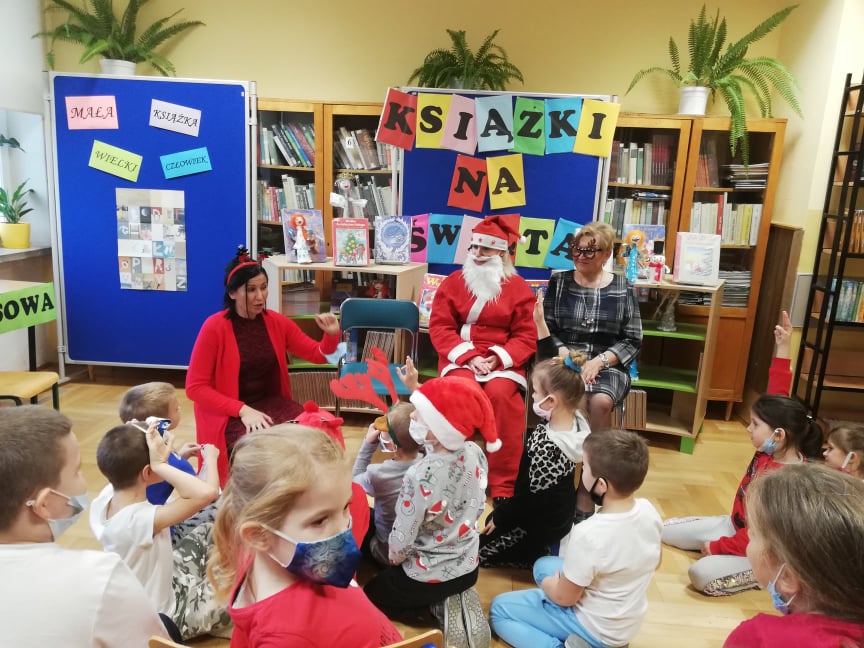 dzieci siedzą na podłodze, odpowiadają na pytania zadawane przez Mikołaja i Elfy