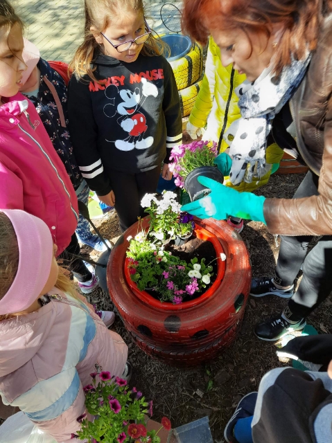 Dzieci sadzą rośliny do skrzynek.
