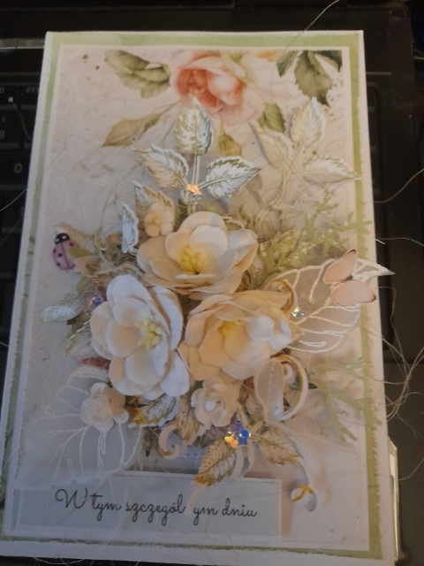Kartka okolicznościowa wykonana z papieru i kwiatów papierowych.
