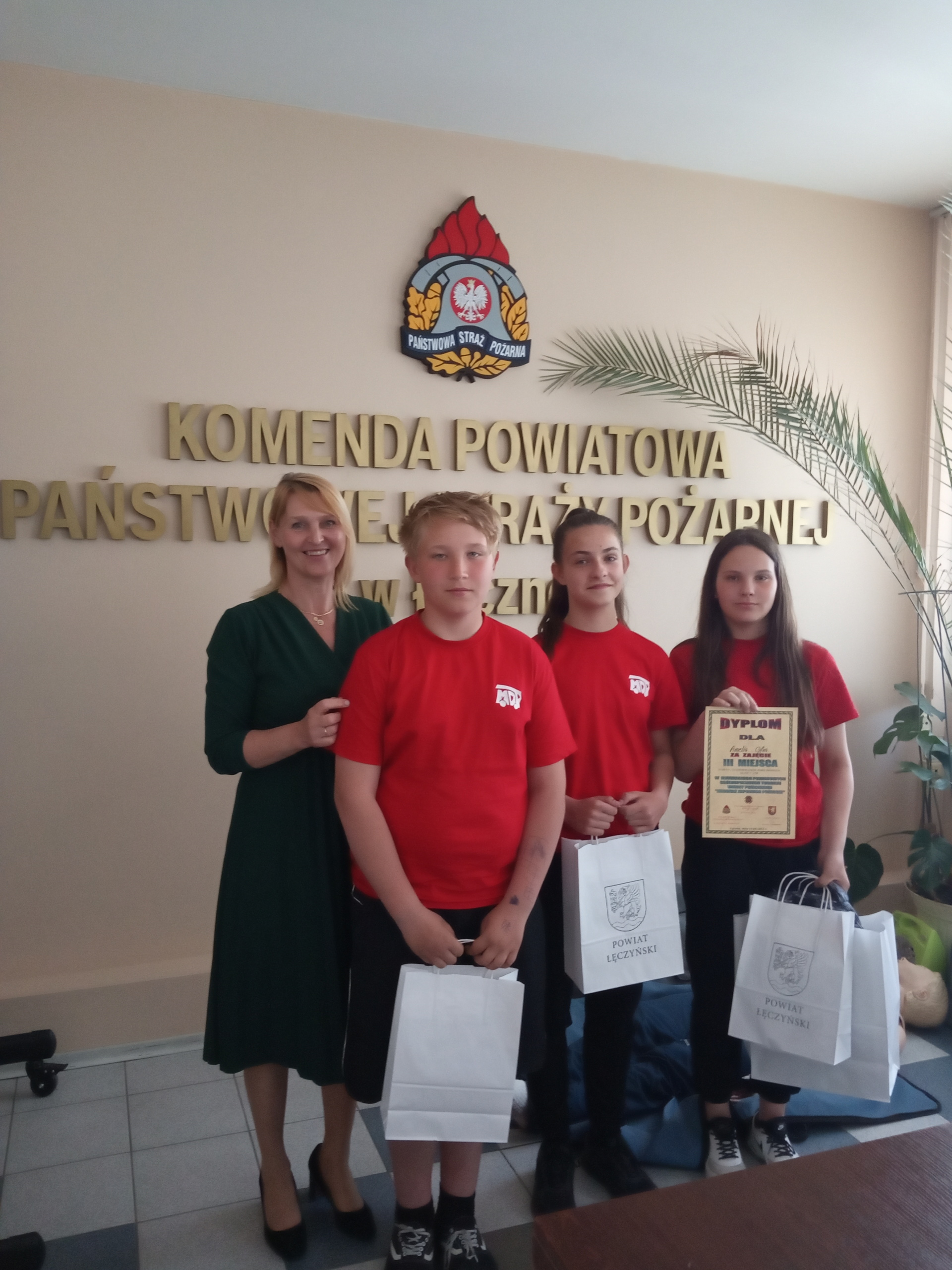 Uczniowie: Amelia Cyfra kl. 6 a, Magdalena Zaborek 7 b, Kacper Jóźwiak kl. 5 e  oraz opiekun p. Lidia Szczęsna prezentują się z dyplomami i nagrodami.