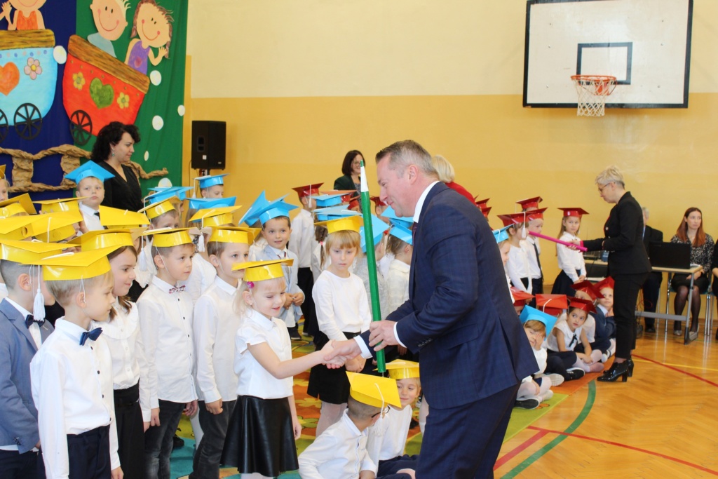 Burmistrz Łęcznej pasuje dzieci z klasy 1c drewnianym ołówkiem.