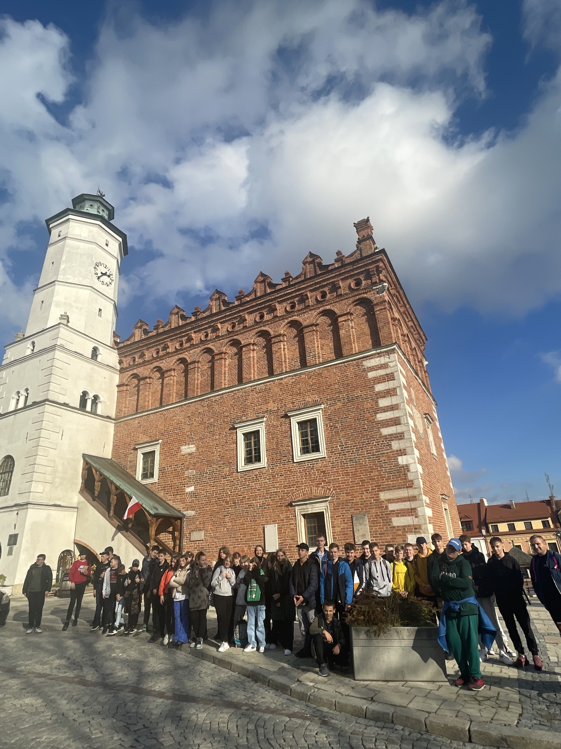 Grupa uczniów stoi przed Ratuszem w Sandomierzu