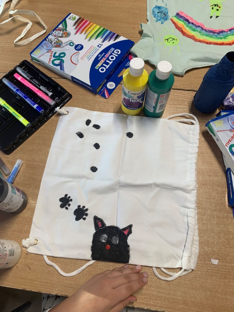 Ozdobiony czarną farbką biały worek, przedstawiający kota i jego odciski łap.