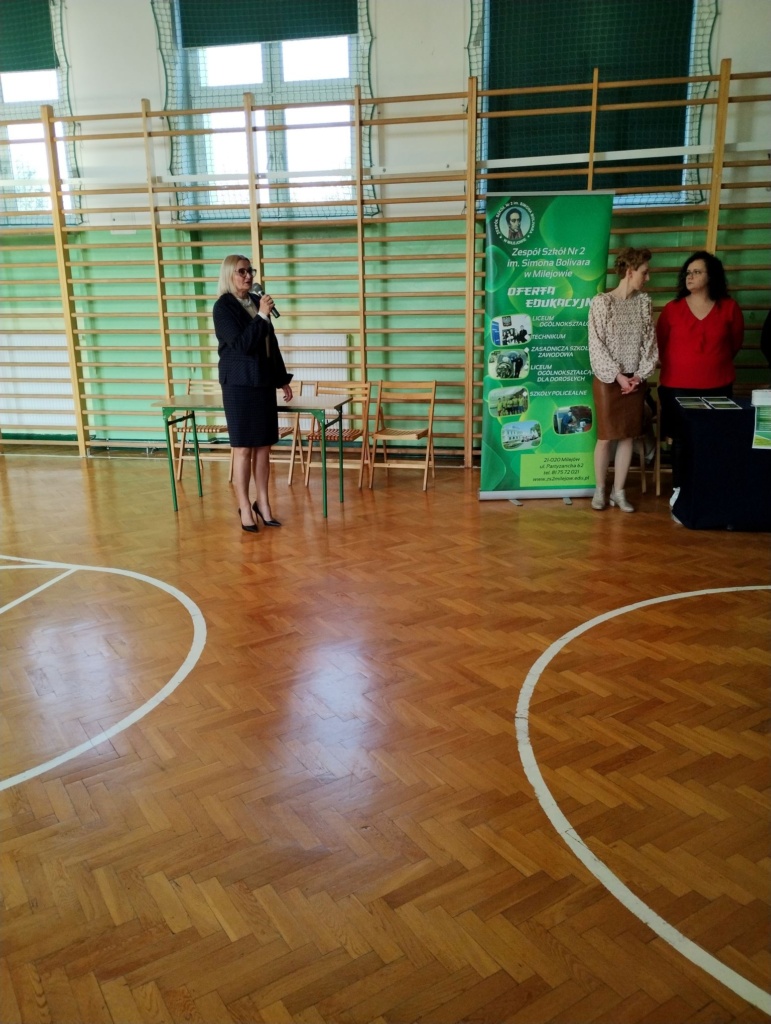 Zdjęcie przedstawia dyrektor szkoły witającą uczestników targów Edukacyjnych