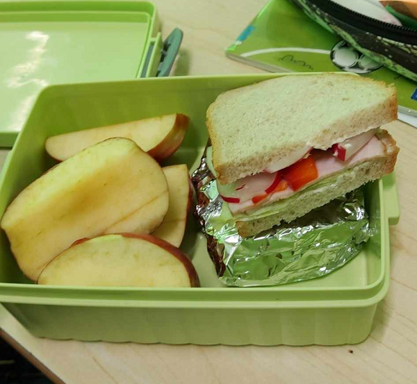 kanapka z warzywami i pokrojone jabłko
