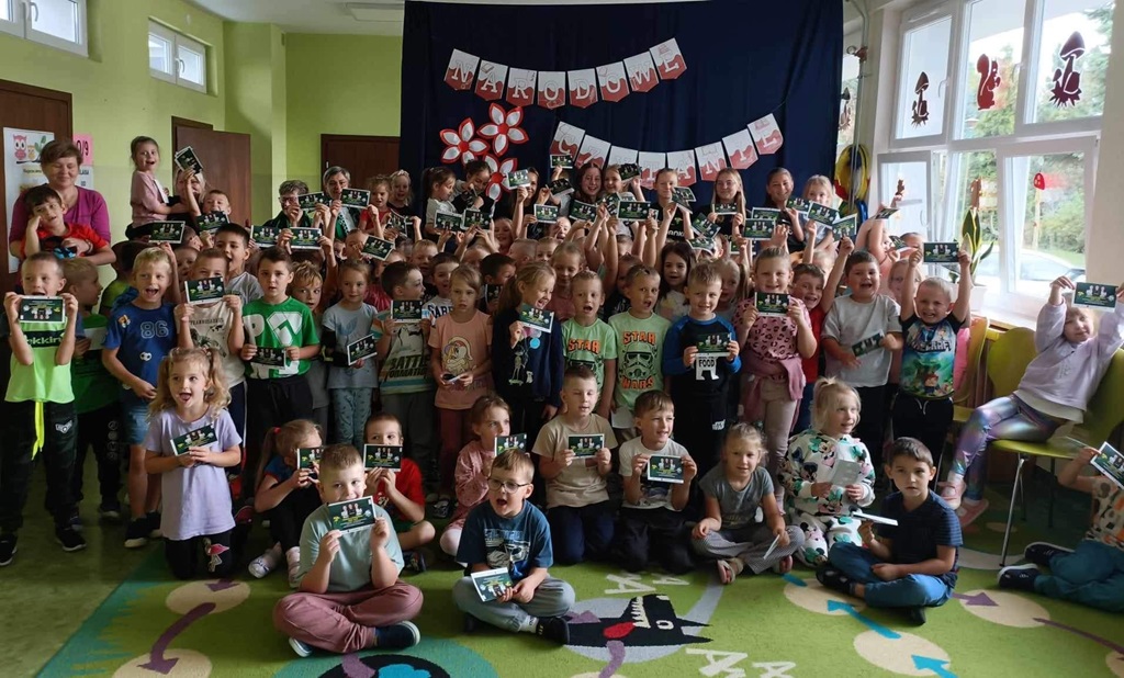 Dzieci stoją na tle napisu Narodowe Czytanie.