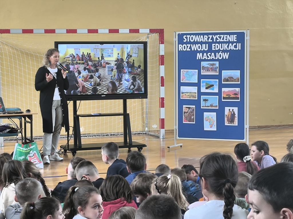 Przedstawicielka Stowarzyszenia Rozwoju Edukacji Masajów pokazująca prezentację multimedialną dla uczniów.