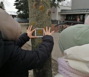 Uczniowie na zajęciach terenowych badają stan zanieczyszczeń powietrza.
