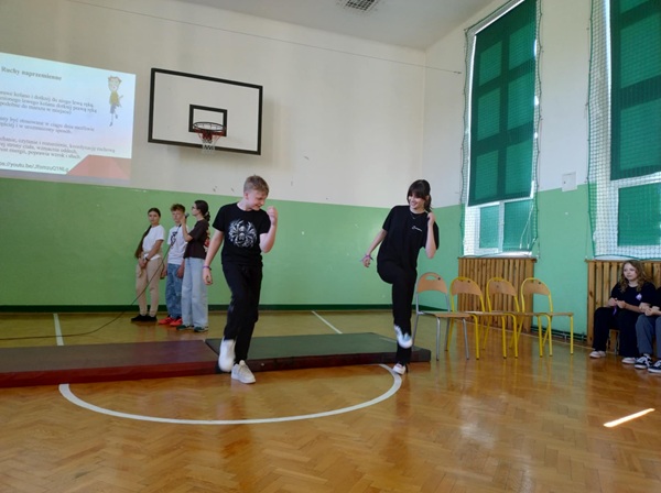 na sali gimnastycznej uczniowie prezentują ćwiczenia relaksacyjne