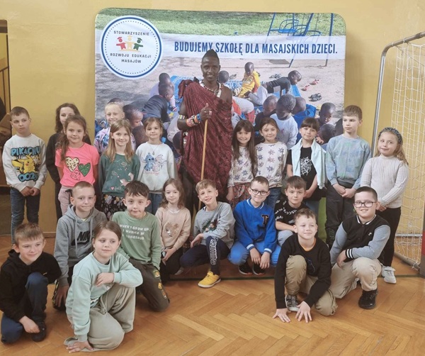Grupowe zdjęcie uczniów klasy 1 z Masajem w tradycyjnym stroju.