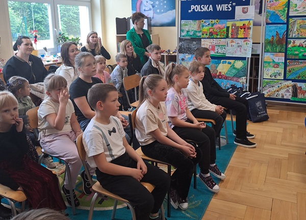 Laureaci konkursu siedzą na krzesłach, czekają na wręczenie nagród