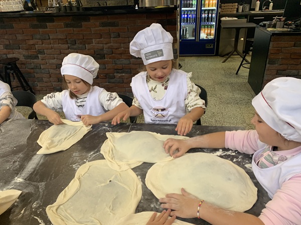 Troje dzieci formują ciasto na pizze