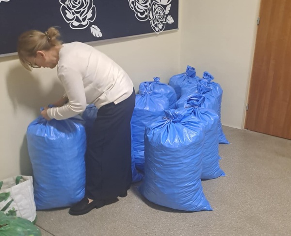 Kobieta zawiązująca worki z nakrętkami.