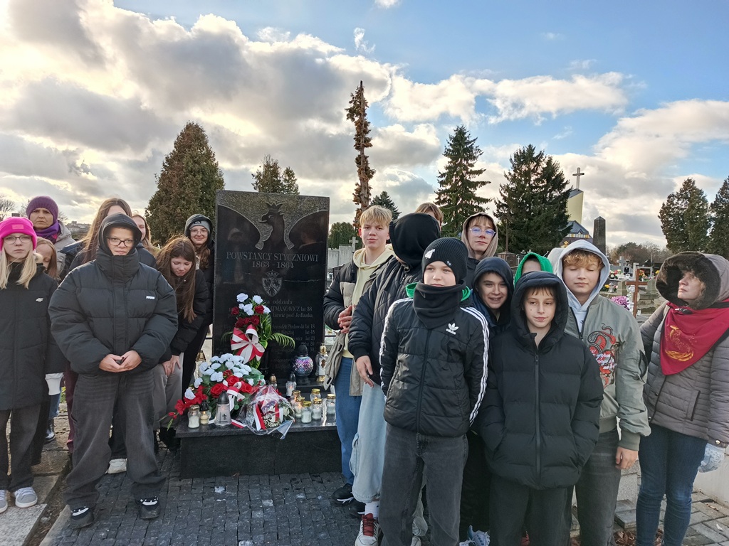 uczniowie stoją przy grobie powstańców styczniowych