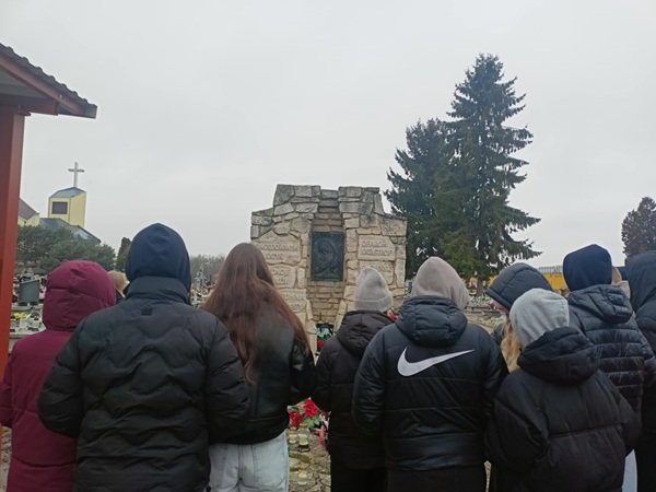 uczniowie stoją na cmentarzu w Łęcznej