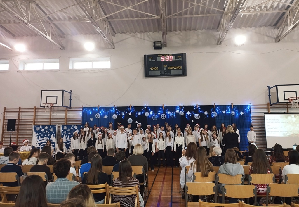 Chór Cantabile wykonuje piosenkę rozpoczynającą koncert świąteczny, w tle widać świąteczną scenografię.