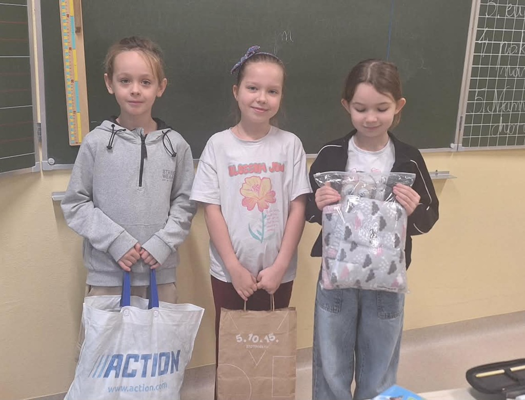 Dzieci trzymają w rękach torby, w których znajdują się artykuły dla zwierząt.