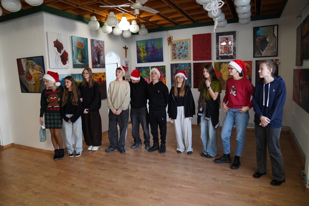 Wolontariusze z opiekunką w trakcie składania życzeń świątecznych.