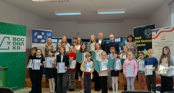 Nagrodzone dzieci trzymają dyplomy. Za dziećmi są organizatorzy konkursu.