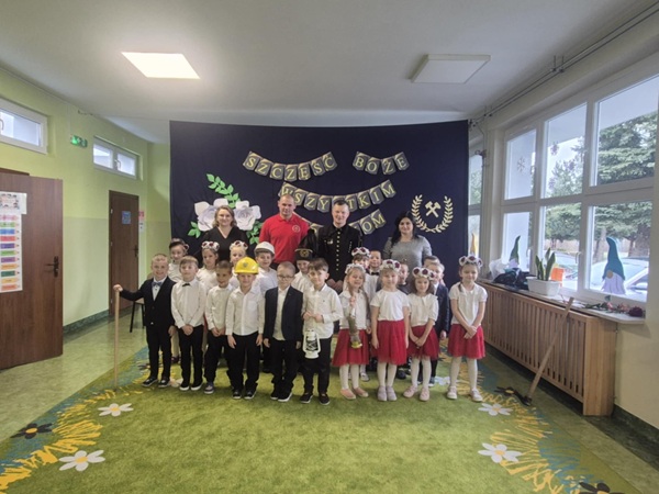 Grupa dzieci z wychowawczyniami górnikami, na tle dekoracji