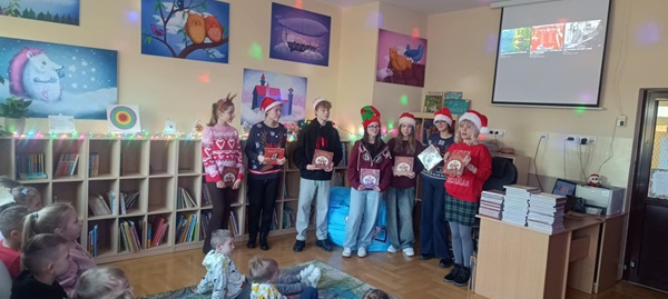 Uczniowie wraz z opiekunem prezentują pierwszakom książki Justyny Bednarek.