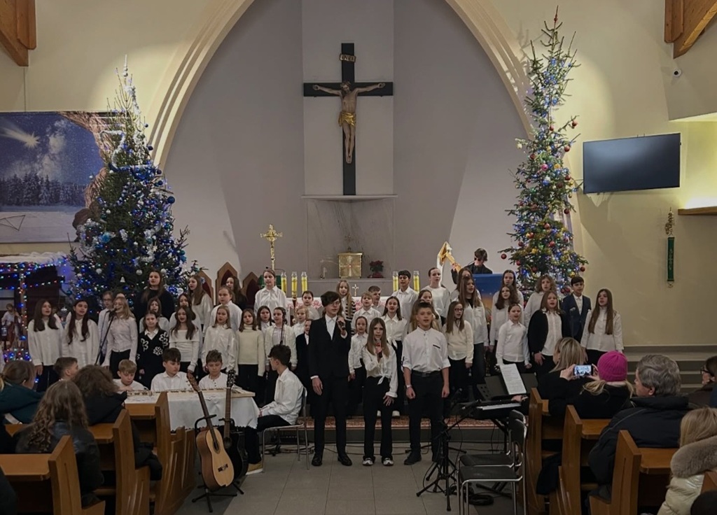 Churzyści w białych koszulach i czarnych spodniach. Z przodu troje wykonują jeden z utworów.