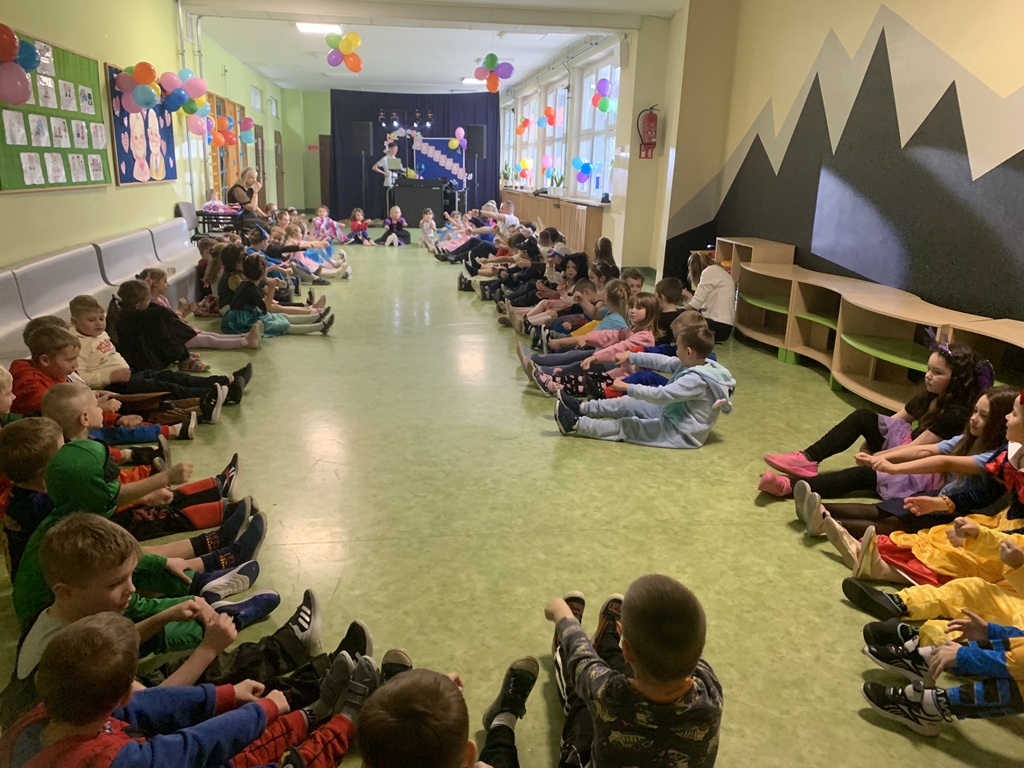 Dzieci siedzą na podłodze z biorąc udział we wspólnej zabawie.