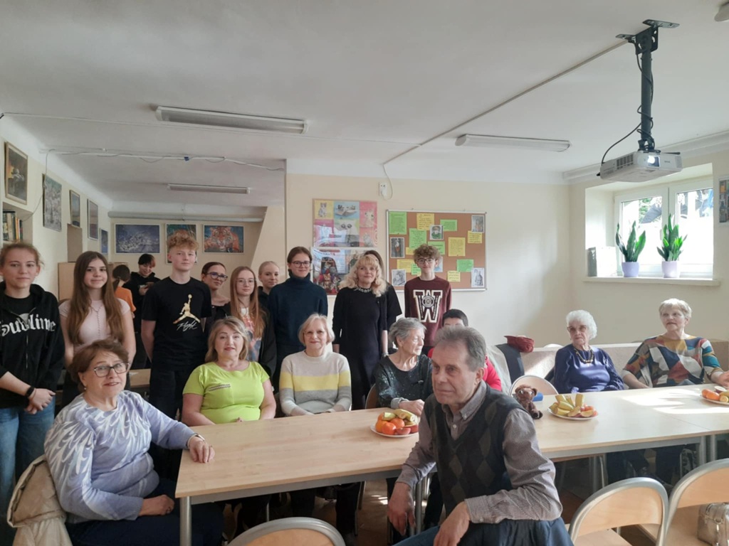 seniorzy z młodzieżą pozują do zdjęcia