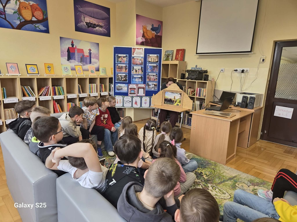 Uczniowie oglądający przedstawienie w teatrzyku kamishibai.