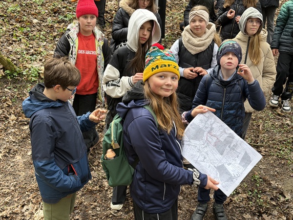 uczniowie z mapą podczas zajęć terenowych