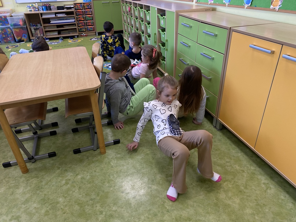 dzieci wsparte na stopach i dłoniach z brzuchem do góry na którym leży but