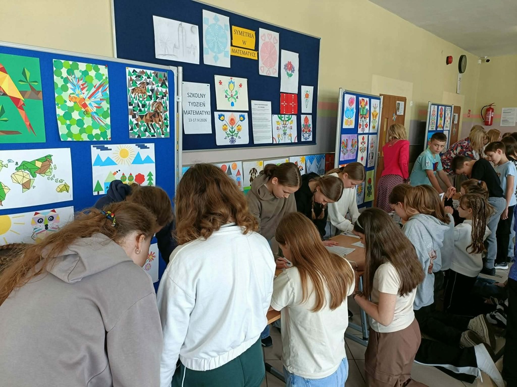 uczniowie rozwiązują zadania matematyczne, w tle matematyczne prace plastyczne