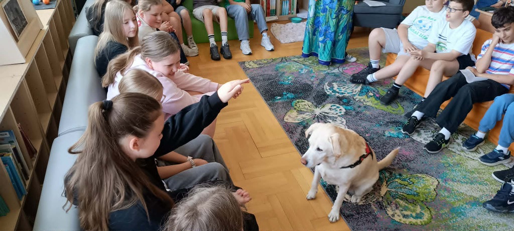 Uczennica z podniesioną ręką wydaje komendę Lei.