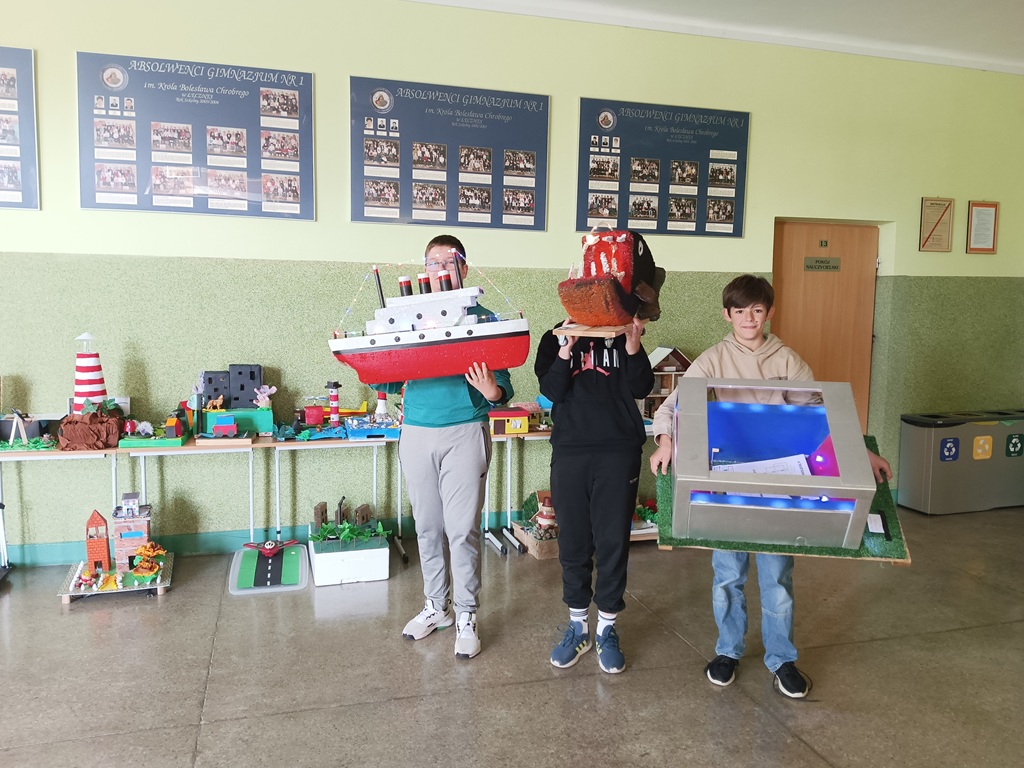 trzech uczniów ze swoimi pracami