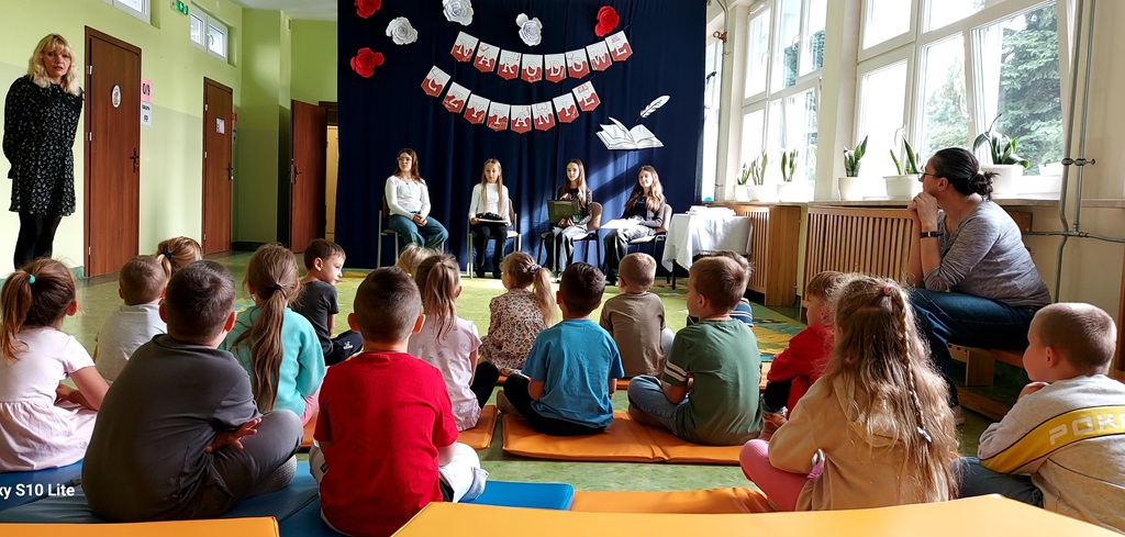 Przedszkolaki siedzą na dywanie i słuchają „Bajki o ziarnie”.