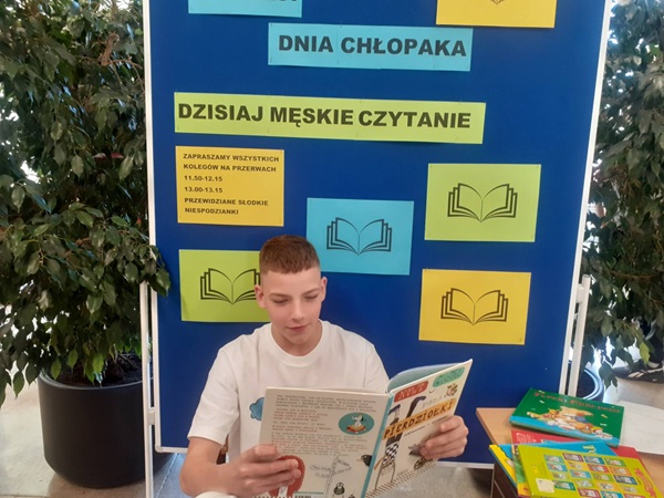 uczeń czyta książkę na tle tablicy z opisem akcji