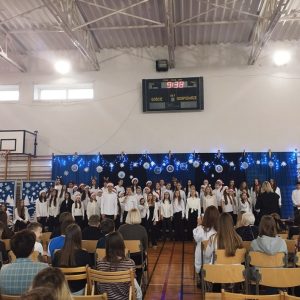 Chór Cantabile wykonuje piosenkę rozpoczynającą koncert świąteczny, w tle widać świąteczną scenografię.