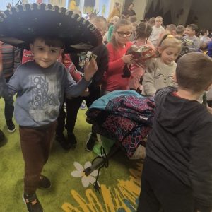 Dzieci oglądają eksponaty z Meksyku. Chłopiec przymierza sombrero.