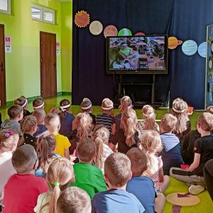 Dzieci oglądają na monitorze wideorelację z realizacji projektu „Kosmos”