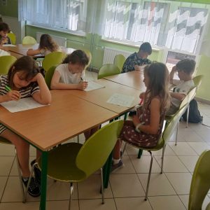 Grupa uczniów uczestników konkursu przy stoliku.