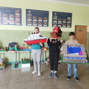 trzech uczniów ze swoimi pracami