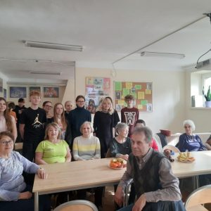 seniorzy z młodzieżą pozują do zdjęcia